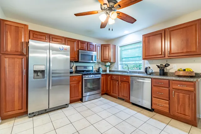 a kitchen with stainless steel appliances granite countertop a refrigerator and a sink