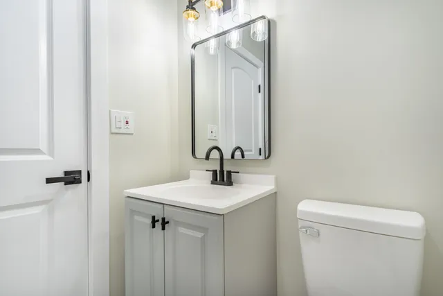 a bathroom with a sink a toilet and mirror
