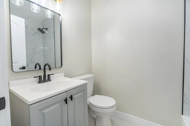 a bathroom with a sink a toilet and mirror