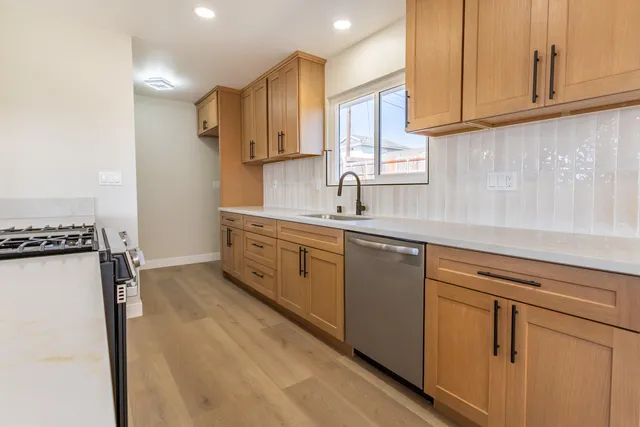 a kitchen with stainless steel appliances granite countertop a sink and a refrigerator