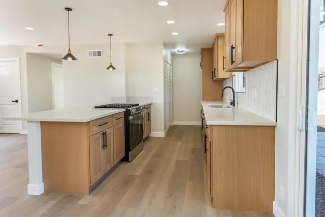 a kitchen with stainless steel appliances granite countertop a sink a stove and a refrigerator