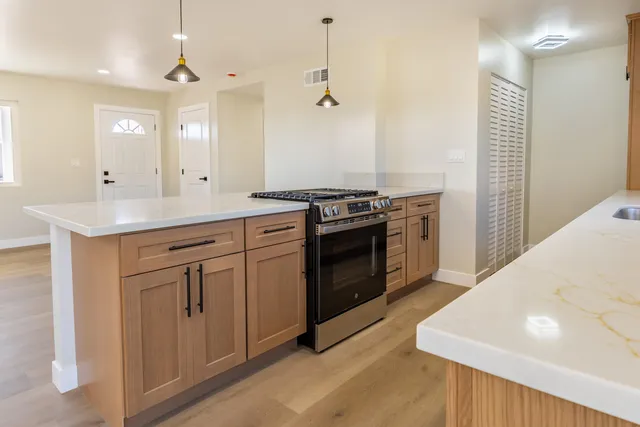 a kitchen with a stove sink and cabinets
