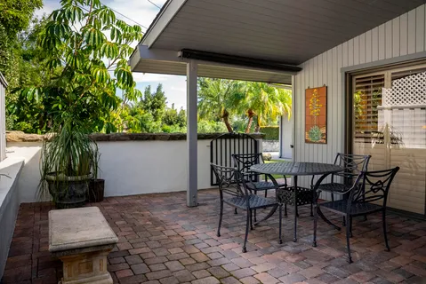 a view of a patio with table and chairs and potted plants