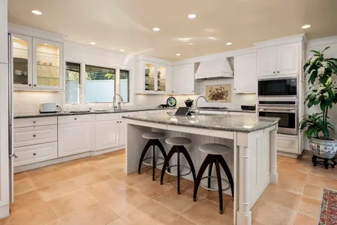 a kitchen with stainless steel appliances granite countertop a stove a sink a refrigerator and a microwave