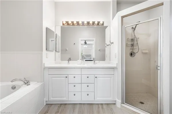 a bathroom with a double vanity sink mirror and bathtub