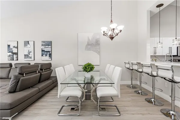 a view of a livingroom with furniture a chandelier and wooden floor