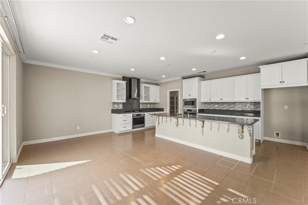 9719 La Vine Court Rancho Cucamonga, CA 91701 - Photo 10 of 39 a kitchen with stainless steel appliances kitchen island granite countertop a stove a sink and a refrigerator