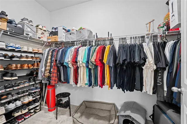 a view of walk in closet with clothes and shoes