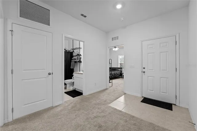 a view of a hallway with closet and a living room