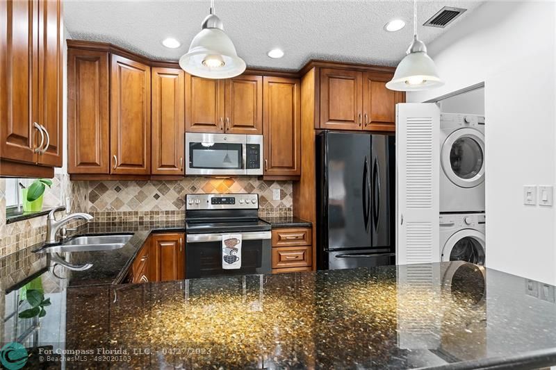 Timberwalk Boca Raton, FL 33428 - Photo 12 of 35 a kitchen with kitchen island granite countertop a stove a refrigerator and a sink