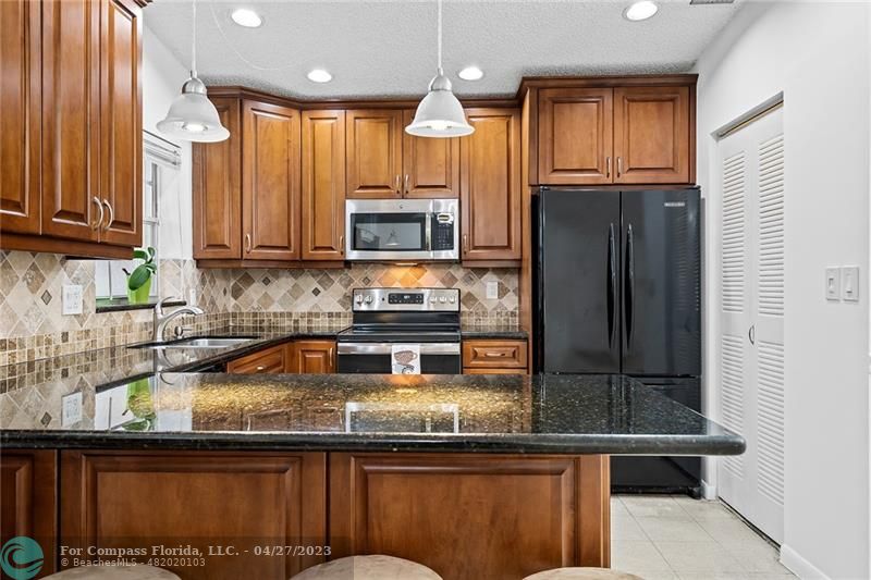 Timberwalk Boca Raton, FL 33428 - Photo 14 of 35 a kitchen with kitchen island granite countertop a sink stove and microwave