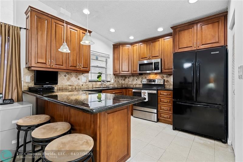 Timberwalk Boca Raton, FL 33428 - Photo 15 of 35 a kitchen with stainless steel appliances granite countertop a refrigerator a stove a sink and a microwave