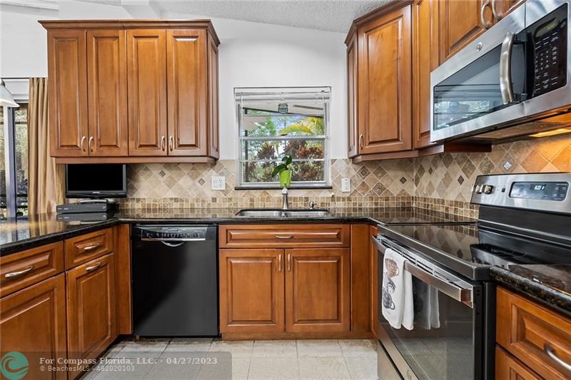 Timberwalk Boca Raton, FL 33428 - Photo 16 of 35 a kitchen with stainless steel appliances granite countertop a stove a sink and a microwave