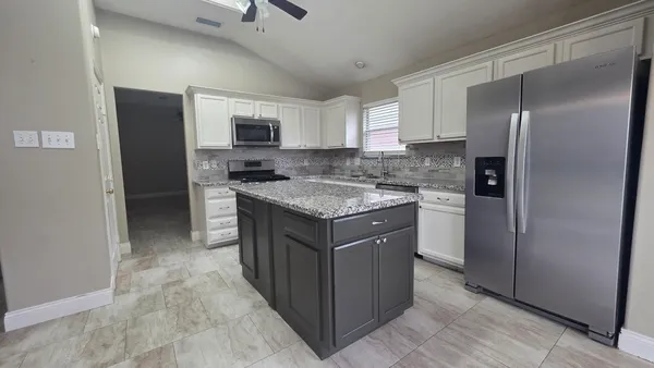 a kitchen with stainless steel appliances granite countertop a refrigerator and a sink
