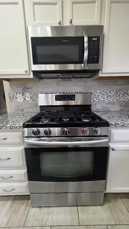 a stove top oven sitting inside of a kitchen