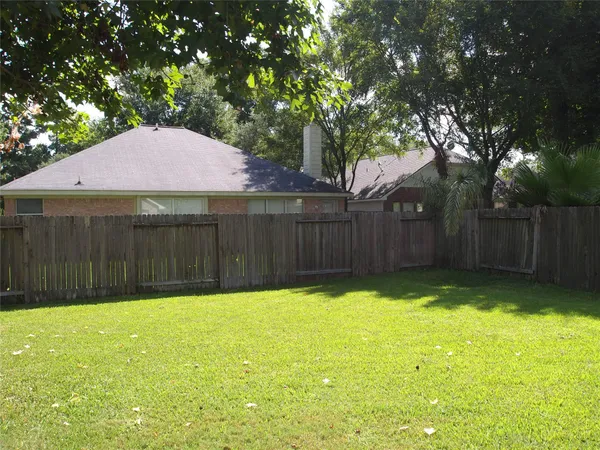 a view of a yard with wooden fence