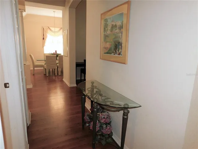 a view of a hallway with wooden floor and a table in a room