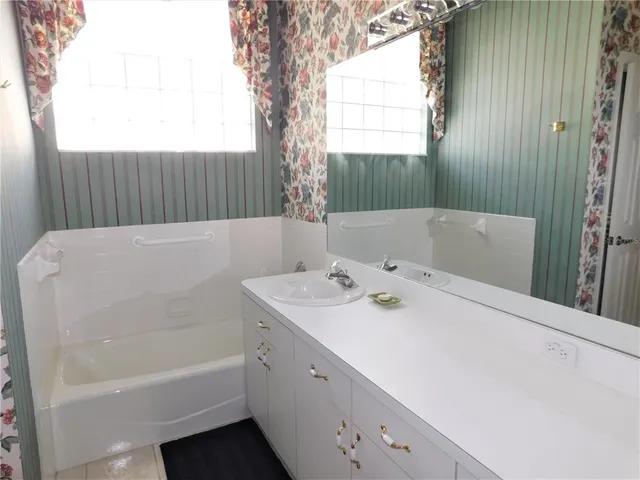 a bathroom with a tub sink and vanity