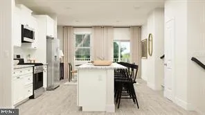 a kitchen with kitchen island a counter top space a sink stainless steel appliances and cabinets