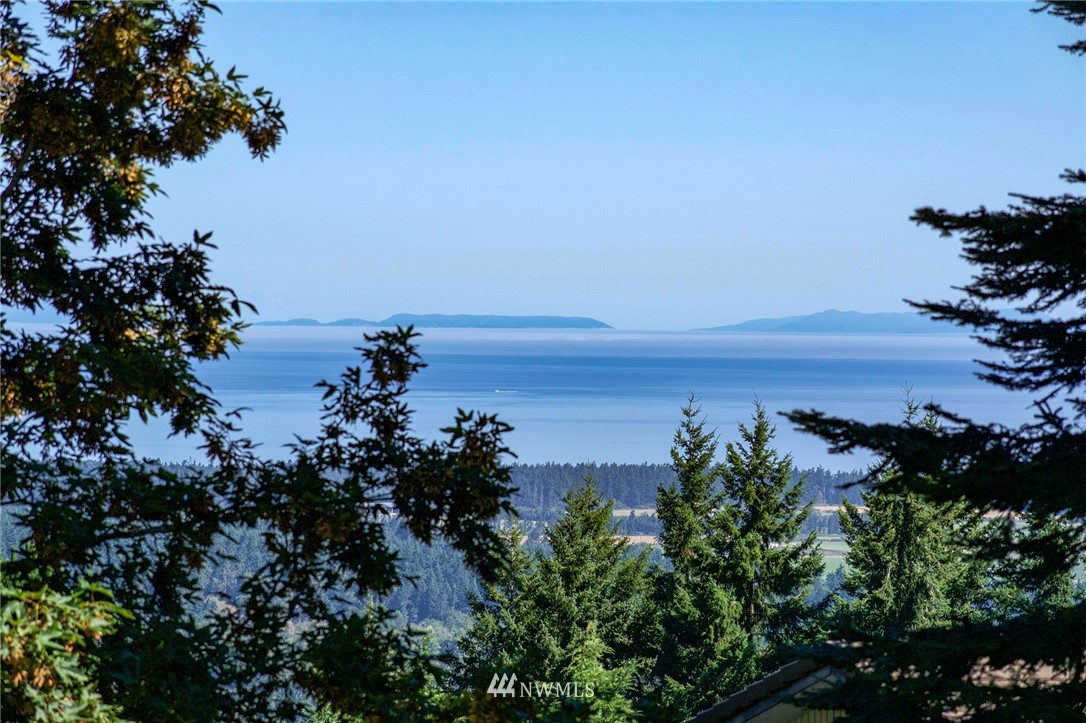 9999 Ravens Ridge Road Sequim, WA 98382 - Photo 21 of 40 a view of a large body of water with a building in the background