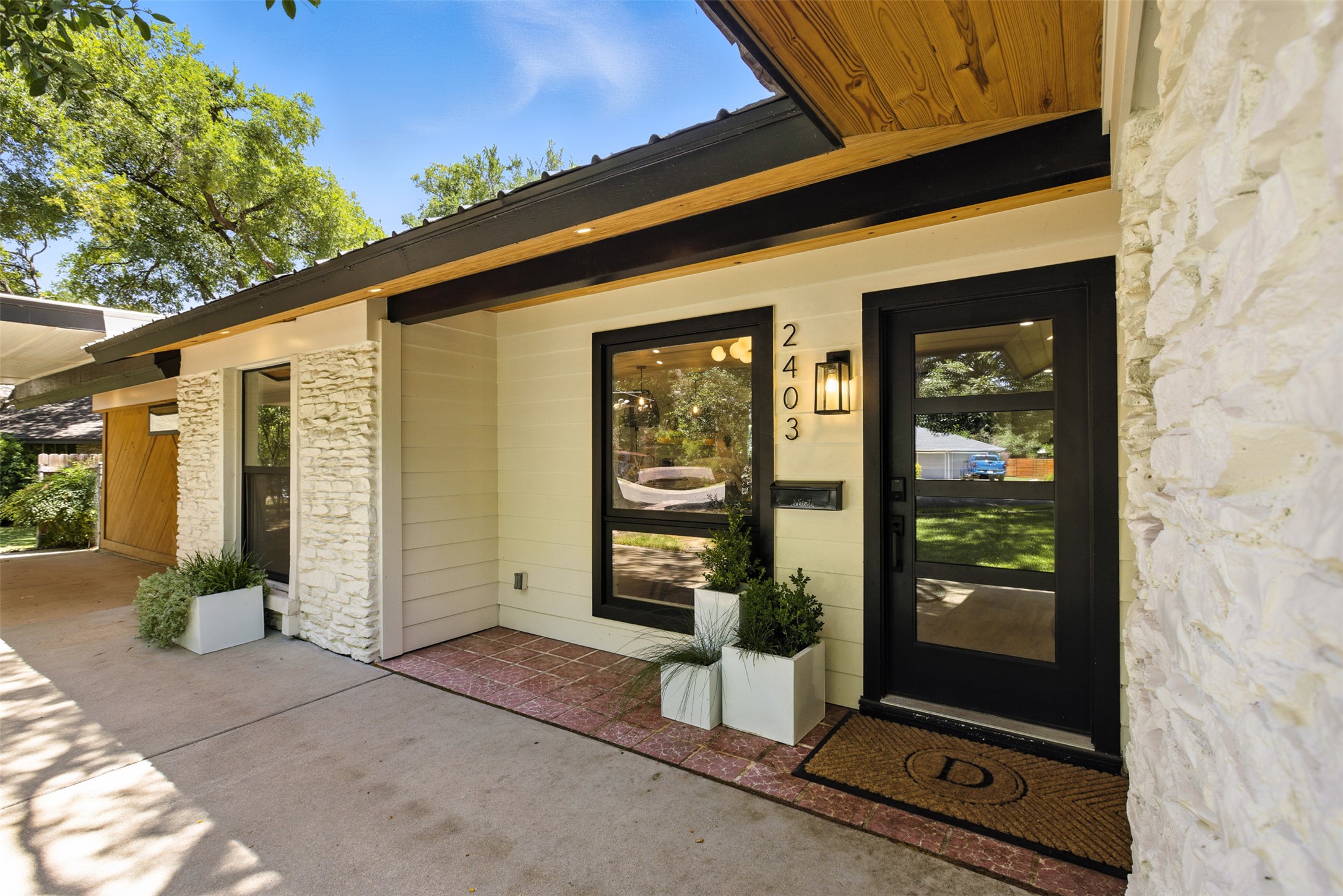 2403 Gateshead Circle Austin, TX 78745 - Photo 6 of 22 A striking modern facade with contrasting textures and inviting entry elements.