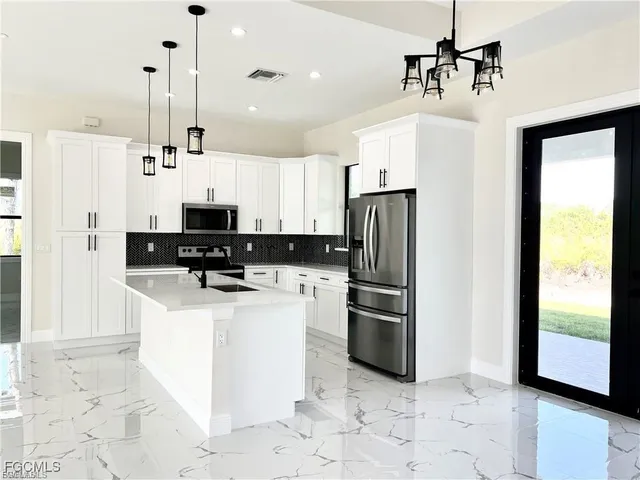 a kitchen with stainless steel appliances a refrigerator sink and microwave
