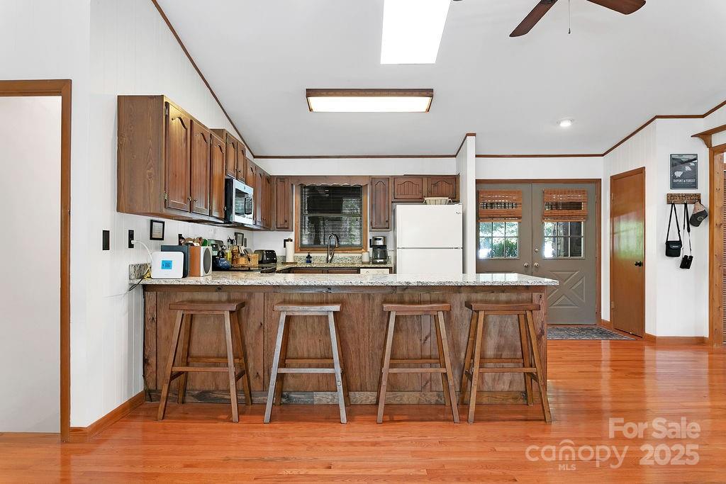58 Warwaseeta Court Brevard, NC 28712 - Photo 20 of 48 a kitchen with stainless steel appliances granite countertop a stove top oven a sink a dining table and chairs with wooden floor