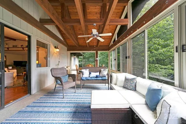 a living room with furniture a ceiling fan and a large window