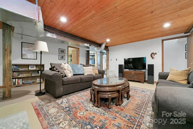 a view of an empty room with furniture and a window