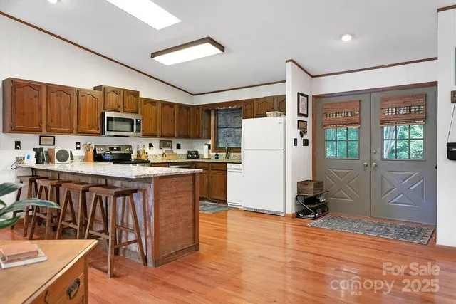 a kitchen with granite countertop a refrigerator and a stove top oven