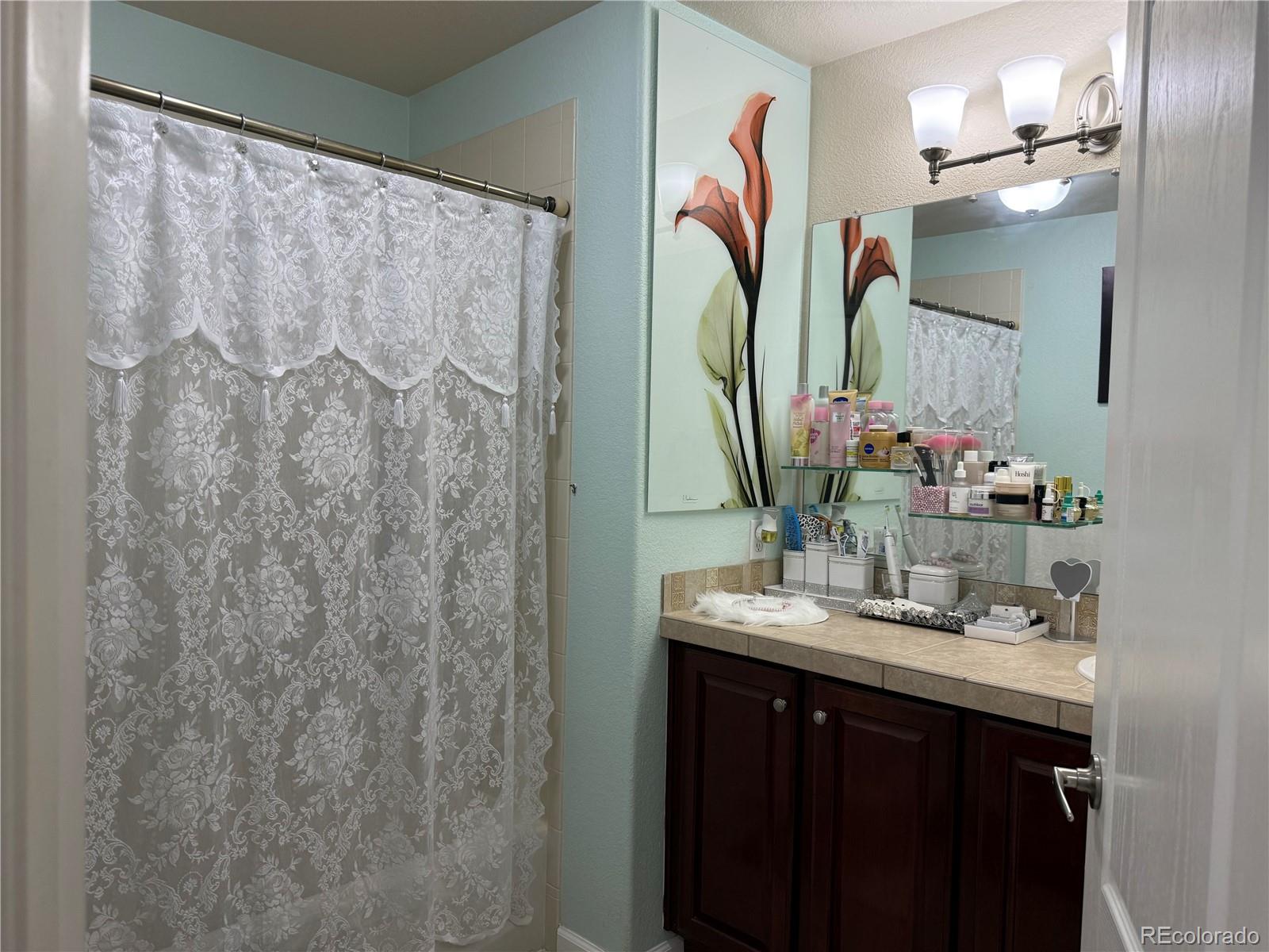 6292 Kilmer Loop, Unit 204 Golden, CO 80403 - Photo 17 of 27 a bathroom with a sink vanity mirror and a shower