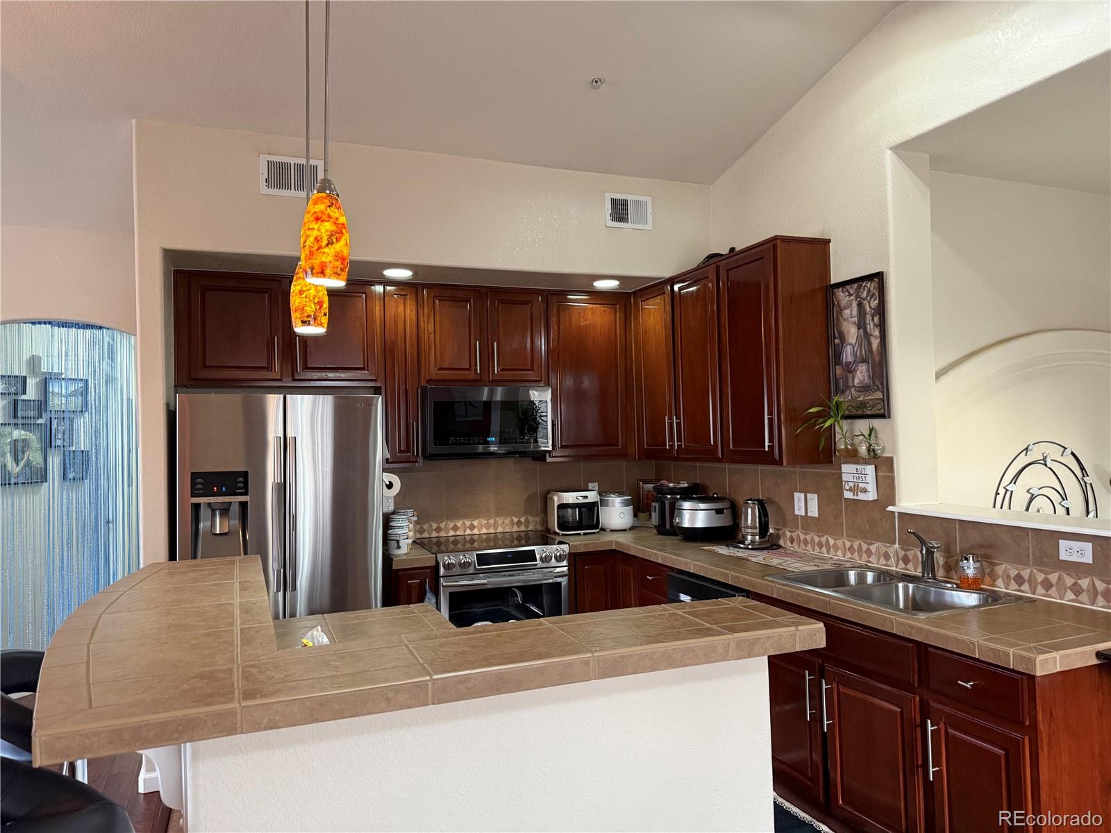 6292 Kilmer Loop, Unit 204 Golden, CO 80403 - Photo 2 of 27 a kitchen with stainless steel appliances a sink a stove a refrigerator cabinets and a counter top space