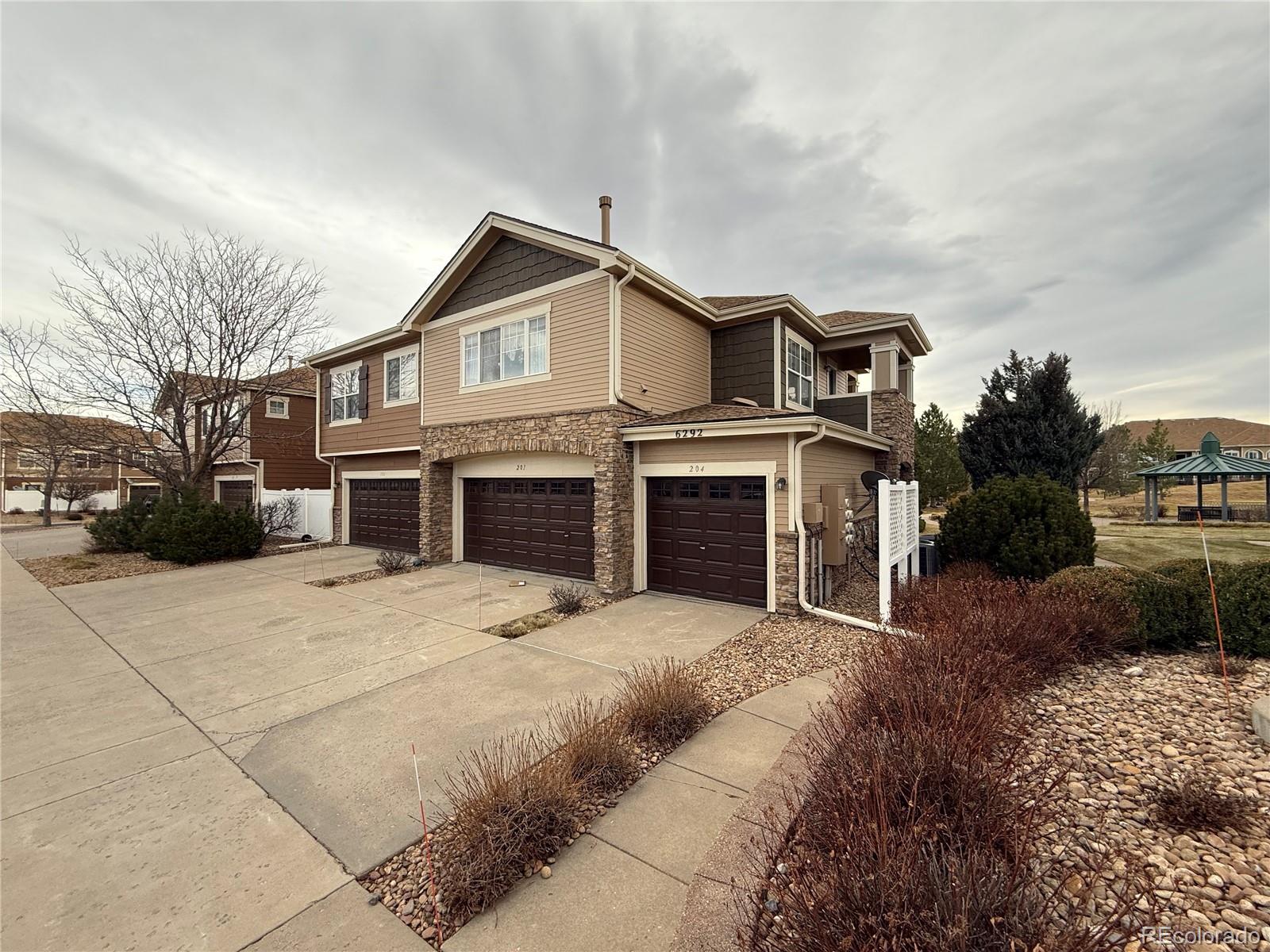 6292 Kilmer Loop, Unit 204 Golden, CO 80403 - Photo 23 of 27 a front view of a house with a yard and garage