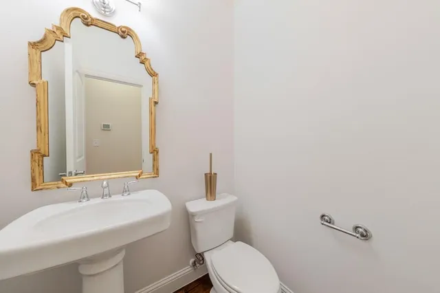 a bathroom with a sink a toilet and mirror