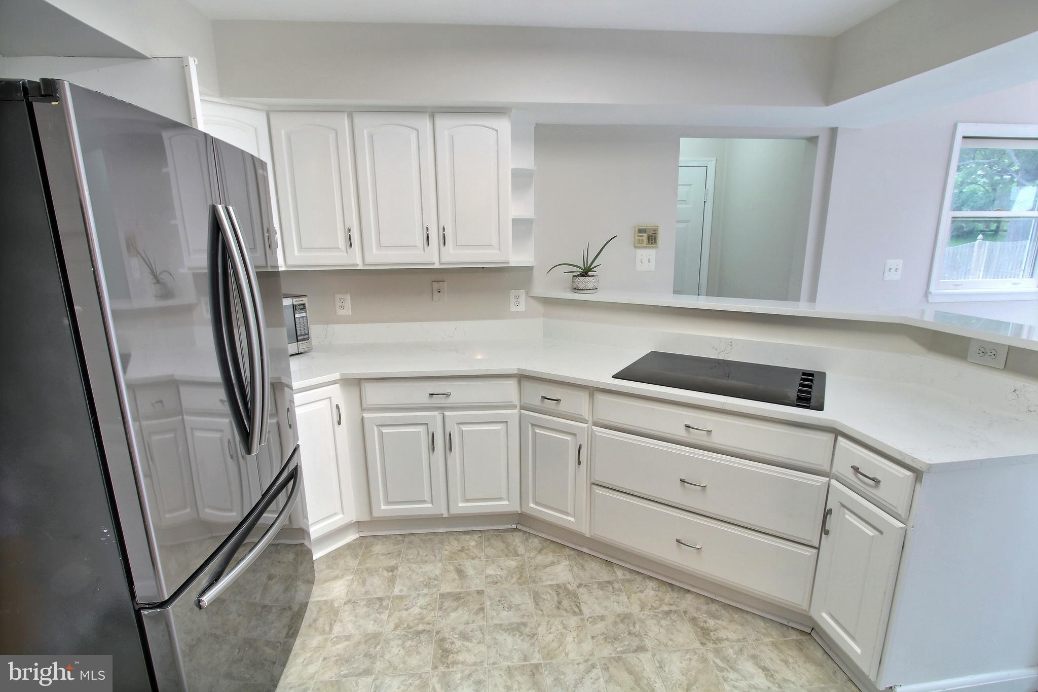 813 Pointer Ridge Drive Gaithersburg, MD 20878 - Photo 13 of 43 a kitchen with white cabinets and refrigerator