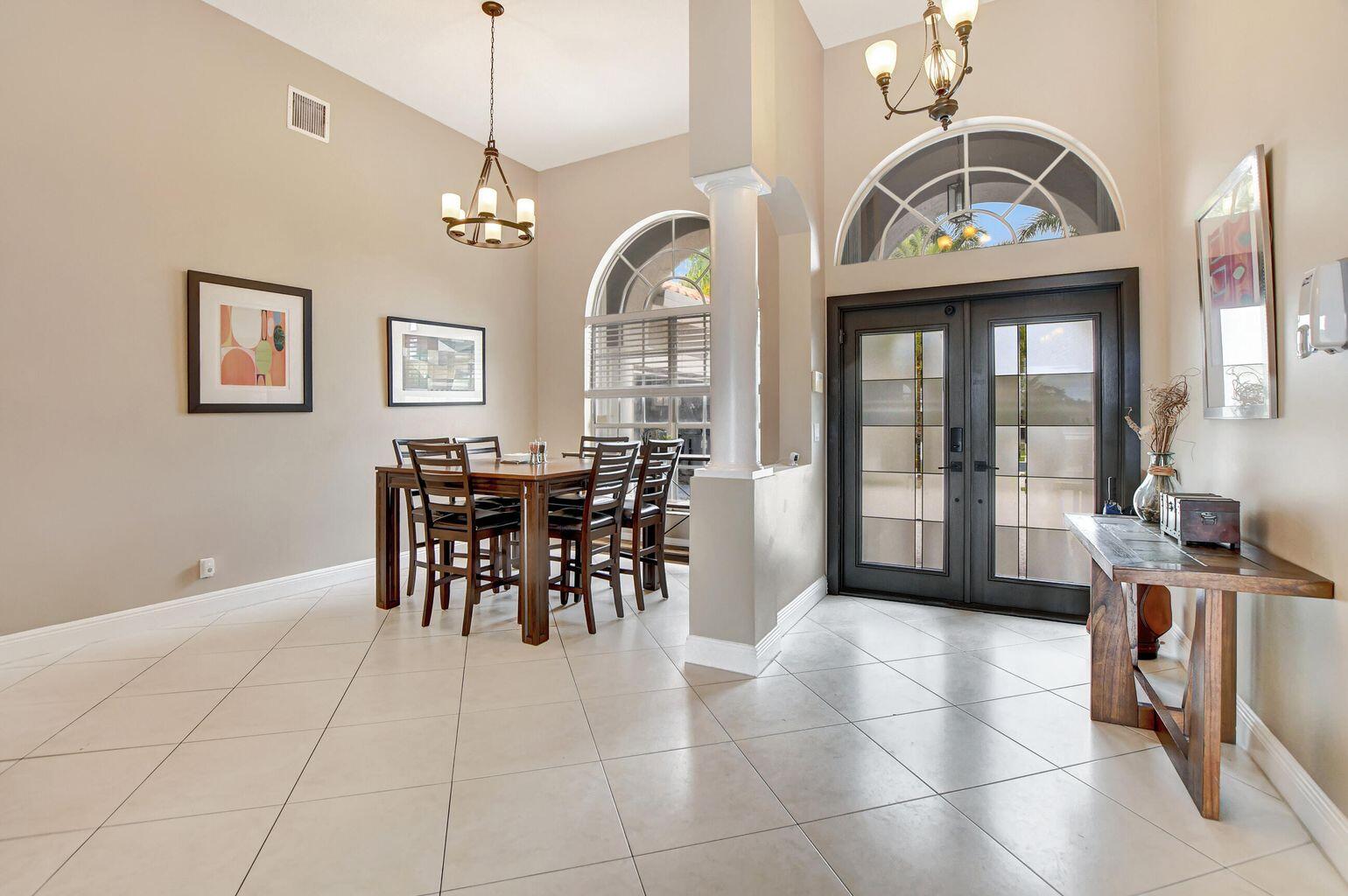12364 Clearfalls Drive Boca Raton, FL 33428 - Photo 19 of 32 a view of a dining room with furniture and a chandelier