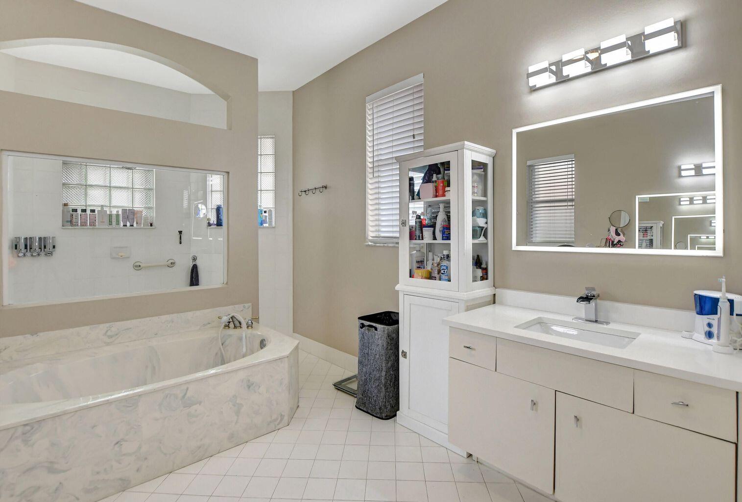 12364 Clearfalls Drive Boca Raton, FL 33428 - Photo 7 of 32 a bathroom with a tub a sink and mirror