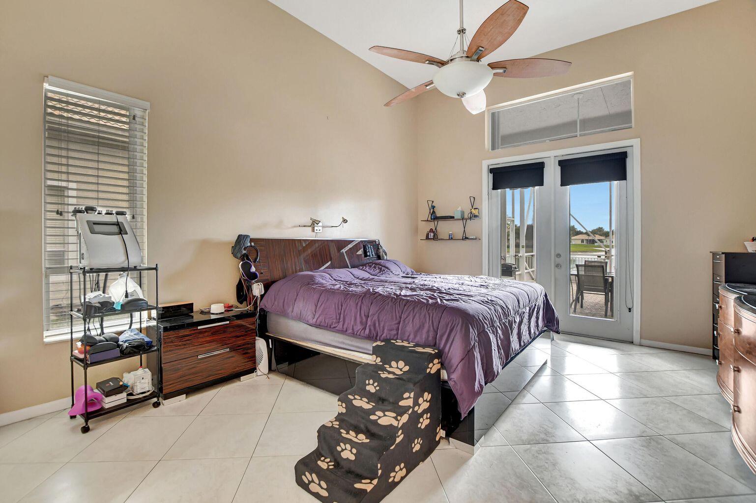 12364 Clearfalls Drive Boca Raton, FL 33428 - Photo 8 of 32 a bedroom with a bed and a window