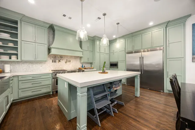 a kitchen with kitchen island a sink stove and refrigerator