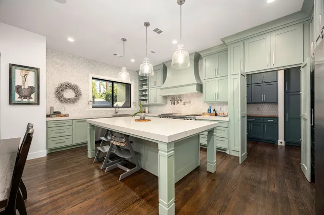 a kitchen that has a lot of cabinets a sink and a wooden floor in it