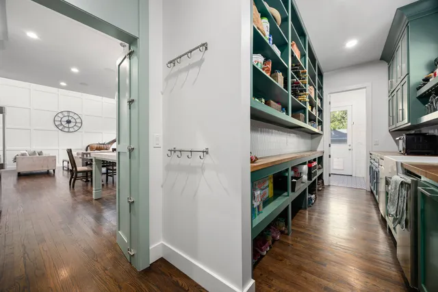 a view of a hallway with seating and hardwood floor