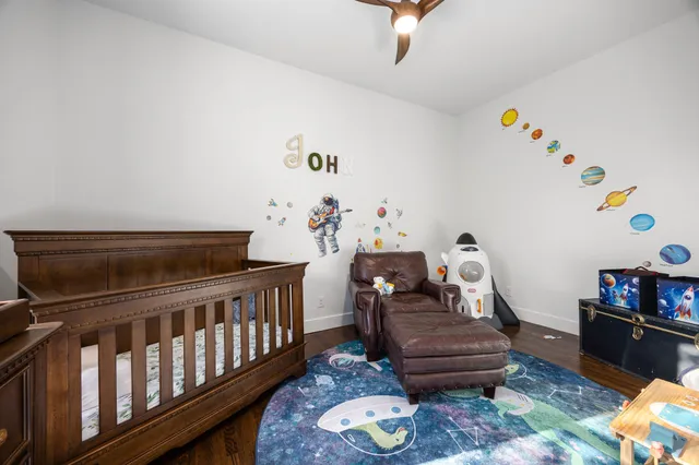 a bedroom with bed and wooden floor