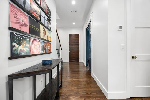 a view of a hallway with wooden floor and furniture