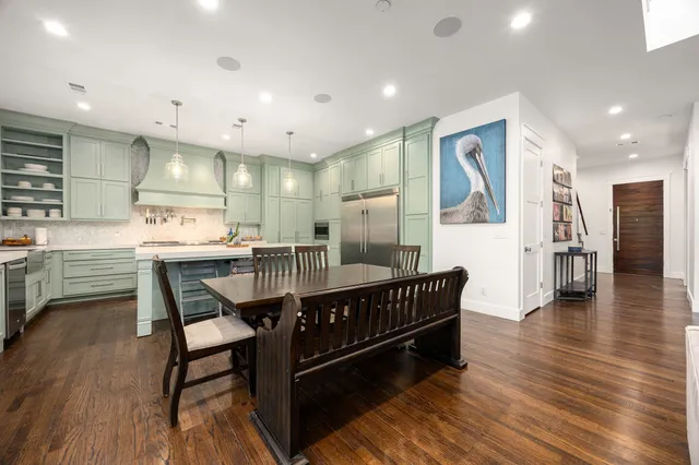 a kitchen with stainless steel appliances kitchen island granite countertop a table chairs and a refrigerator