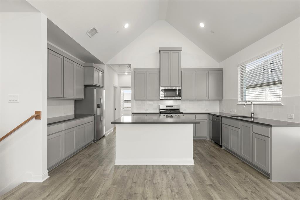 2543 Brunswick Way Allen, TX 75013 - Photo 19 of 34 a large kitchen with stainless steel appliances kitchen island granite countertop a stove a sink dishwasher and a refrigerator