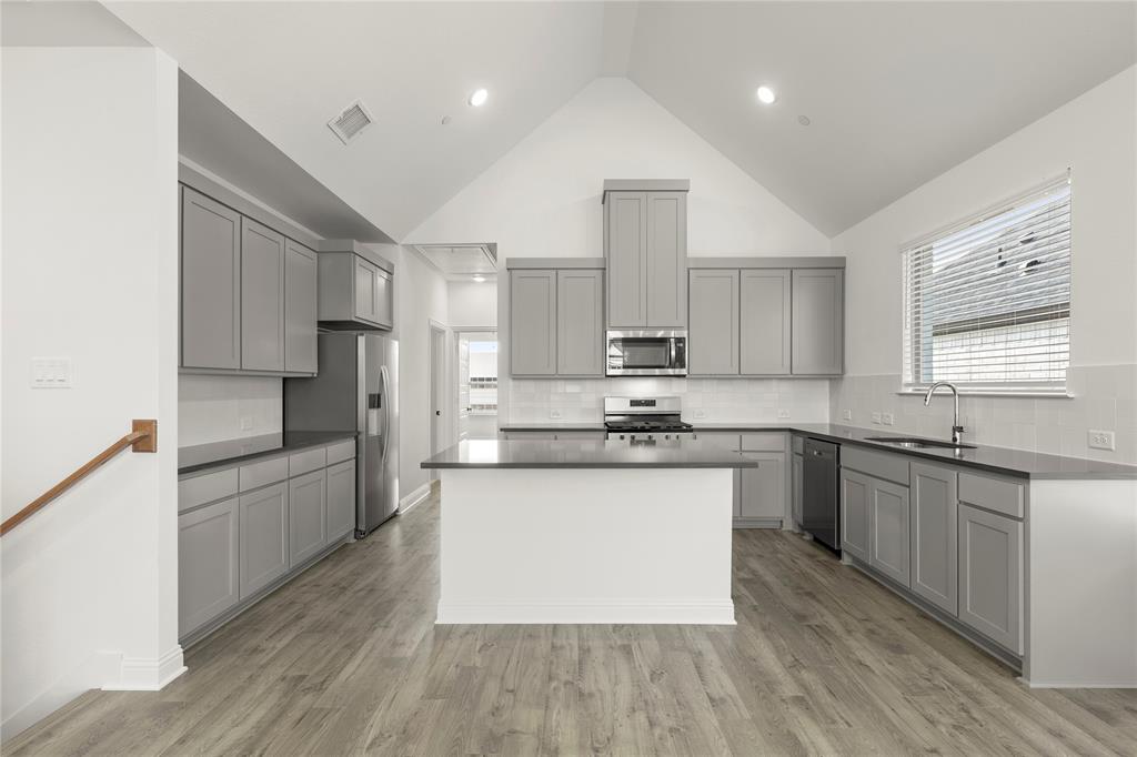 2543 Brunswick Way Allen, TX 75013 - Photo 25 of 38 a large kitchen with stainless steel appliances kitchen island granite countertop a stove a sink dishwasher and a refrigerator