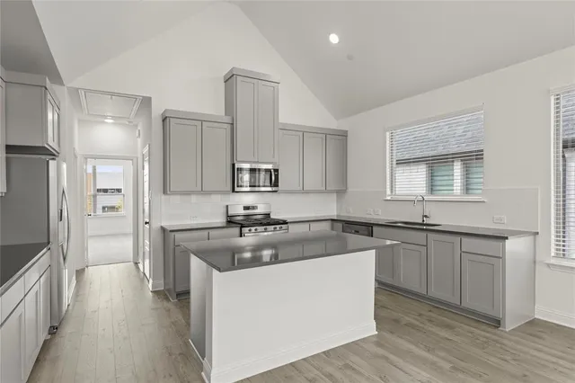 a kitchen with stainless steel appliances granite countertop a sink stove and refrigerator