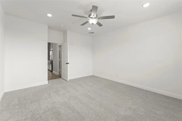 an empty room with closet and ceiling fan