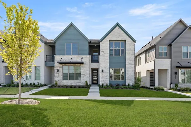 a front view of a house with a yard and trees