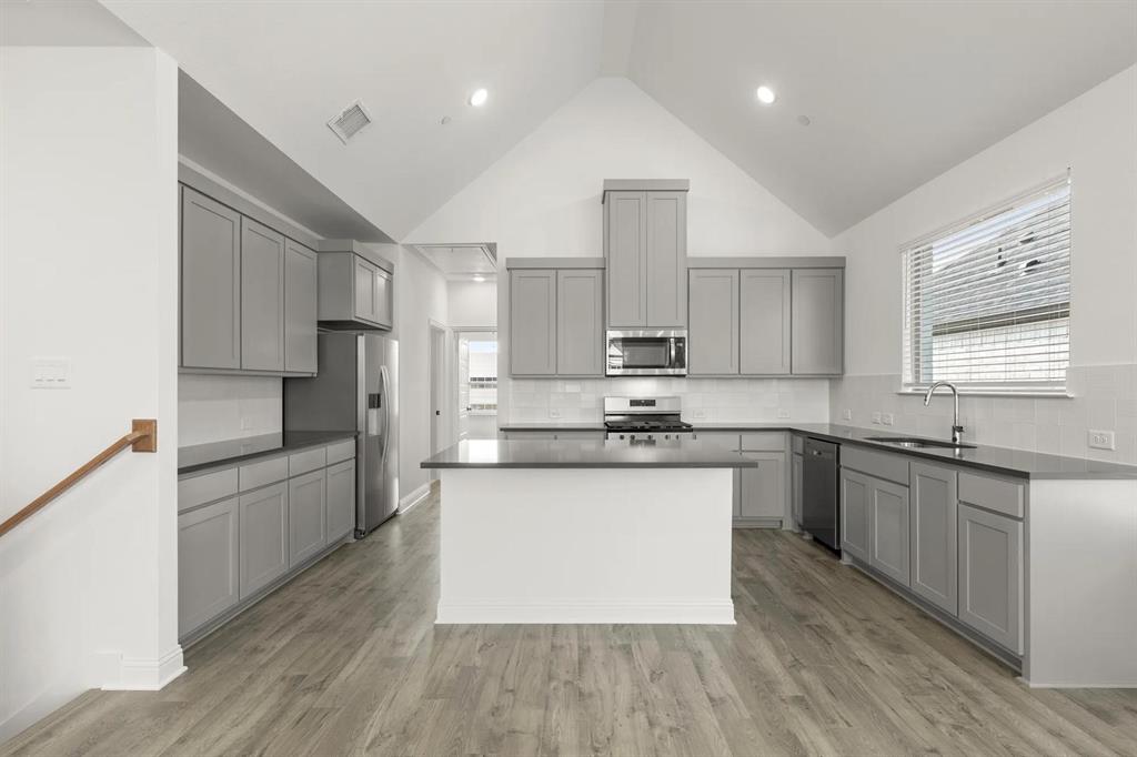 2543 Brunswick Way Allen, TX 75013 - Photo 6 of 38 a large kitchen with stainless steel appliances kitchen island granite countertop a stove a sink dishwasher and a refrigerator